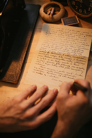 ลายมือ, กระดาษ, แสงที่อบอุ่น, มุมมองที่ใกล้ชิด, คนเขียน, บทกวี, โต๊ะทำงานวินเทจ, นาฬิกาโบราณ, หนังสือหนัง, ที่เขี่ยบุหรี่, ปากกา