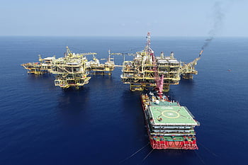 aerial view, oil rig, offshore platforms, blue sea, clear skies, multiple platforms, serene ocean, offshore oil, aerial shot, oil industry, deep sea