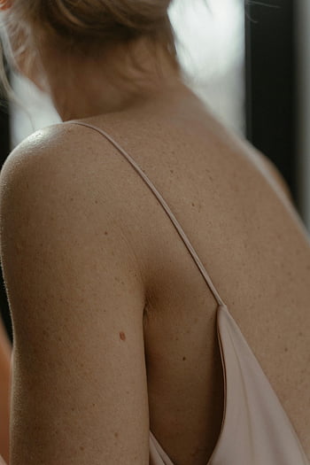 woman's back, freckled skin, soft natural light, skin texture, close-up photo, woman's shoulders, natural beauty, back view, skin detail, woman's upper back, natural lighting