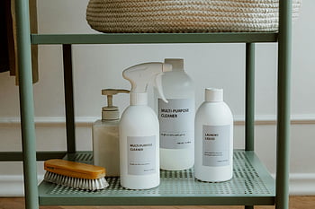 cleaning products, metal shelf, minimalist display, home organization, multi-purpose cleaner, laundry liquid, bottles, shelf organization, cleaning supplies, organized space, white bottles