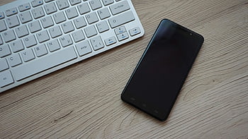 black smartphone, Apple Magic Keyboard, wooden desk, close-up image, modern technology, essentials, keyboard, smartphone, desk setup, tech gadgets, office workspace