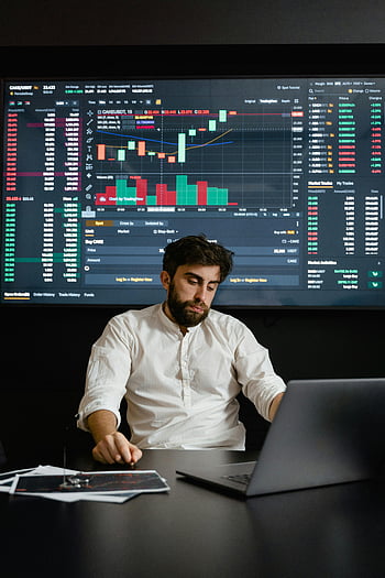 bärtiger Mann, Kryptowährungshandel, Büroarbeit, fokussierter Mann, Handelsdiagramme, Büroumgebung, Finanzanalyse, Aktienmarkt, professioneller Händler, modernes Büro, Technologie -Setup