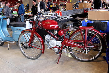 moto guzzi, Hispanie, Guzzino 49cc, moto vintage, vélo rouge, design rétro, scooter classique, exposition intérieure, les gens en arrière-plan, réglage du marché, véhicule à l'ancienne