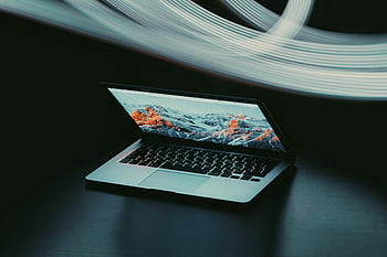 ماك بوك اير،  حاسوب محمول،  الطاولة،  مسارات الضوء الديناميكية،  التكنولوجيا الحديثة،  أجواء،  مفتوح جزئيًا،  مضيئة،  المشهد التقني،  تصميم أنيق،  مساحة العمل