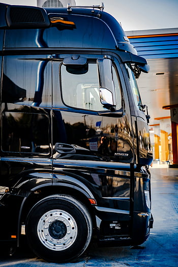 schwarzer LKW, geparkter LKW, Tankstelle, tagsüber, draussen, elegantes Design, Lastwagen, LKW -Reifen, LKW-Spiegel, LKW-Fahrerhaus, LKW-Räder