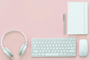 Apple Compact Keyboard, Magic Mouse, corded headphones, pink surface, flat lay, modern workspace, white accessories, minimalist setup, desk organization, productivity tools, office essentials