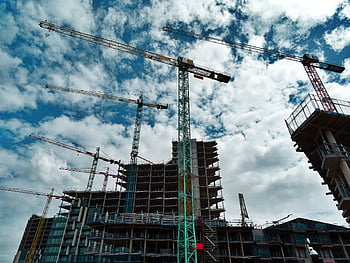 construction site, cranes, skyscrapers, blue sky, urban development, building construction, green crane, yellow crane, construction equipment, high-rise buildings, construction industry