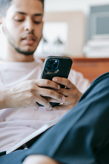 vážný indický muž, Procházení smartphonu, mladý muž, pomocí smartphonu, špunty, uvolněné nastavení, krytý, Neformální outfit