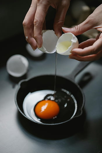 cracking egg, skillet, fresh breakfast, indoor cooking, hands, egg yolk, kitchen, meal preparation, cooking process, food photography, breakfast meal