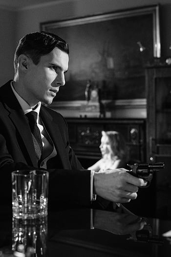 man pointing gun, black and white, cinematic scene, man in suit, holding gun, indoors, dramatic lighting, vintage setting, noir style, tense moment, revolver