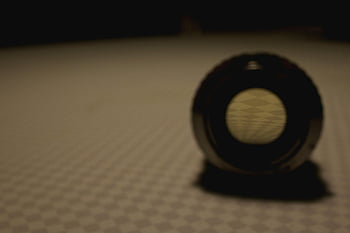 Gray Steel Round Tool, moody close-up, artistic lens, patterned surface, shadow cast, round lens, moody artistic, close-up lens, patterned background, shadow photography, artistic shadow