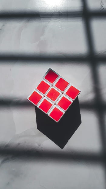 red boxes, Rubik Cube, geometric cube, red squares, white surface, shadow patterns, puzzle cube, cube toy, red and white, cube design, cube shadow