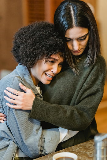 young woman crying, empathetic female friend, comforting hug, expressing empathy, support during difficult time, two young women, emotional support, friendship, emotional connection, difficult emotions, comfort in friendship
