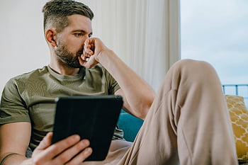 おとこ、 ソファー、 コンピュータタブレット、 カジュアルな服装、 屋内で、 思いやりのある、 タブレット、 座っている、 カジュアルな服、 ホーム設定、 リラックスした