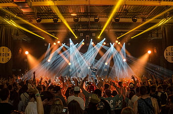 concert, disco house, energetic music, bright lights, lively crowd, indoor event, cheering crowd, music scene, stage lights, concert atmosphere, indoor concert