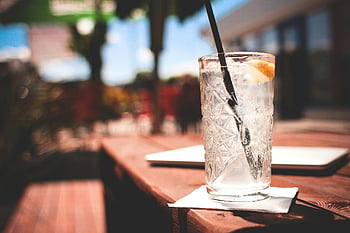 jasné sklenice na pití, gin s tonikem, plátek citronu, letní terasa, občerstvení, studený nápoj, Venkovní nápoj, ledové kostky, sláma, dřevěný stůl, ubrousek