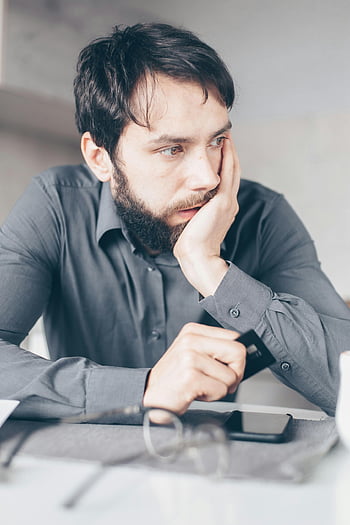 orolig man, gråskjorta, kreditkort, online -bedrägeri, ekonomisk stress, man som håller kreditkort, ekonomisk oro, man i grå skjorta, ekonomiska problem, kreditkortsstress, ekonomisk ångest