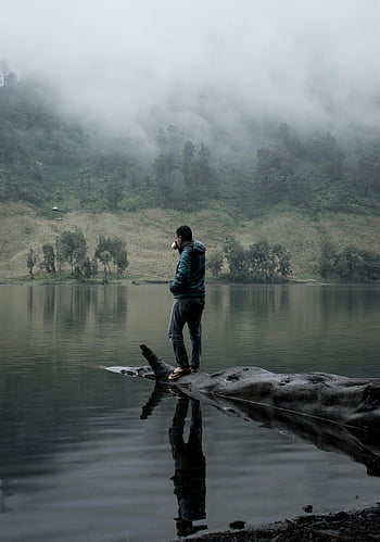 homme debout sur un tronc d'arbre, lac brumeux, East Java, Indonésie, la tranquillité de la nature, réflexion, eau, tronc d'arbre, homme dans la nature, scène paisible, environnement serein