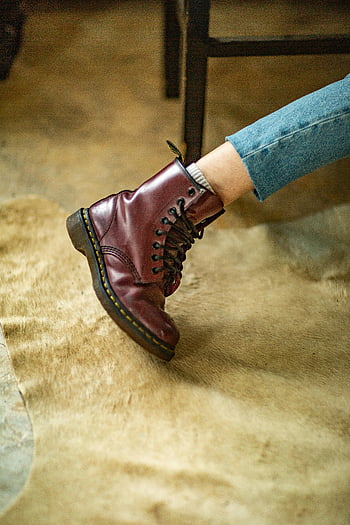 brown leather boot, close-up photography, stylish boot, burgundy leather, laces, indoor beige rug, work boot, leather footwear, close-up shot, indoor setting, beige rug