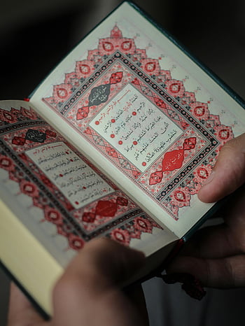 Koran, verzierte Schrift, detailliertes Design, bunte Seiten, Nahaufnahme, Islamischer Text, religiöses Buch, heiliges Buch, Arabische Kalligraphie, rote Seiten, Koran offen
