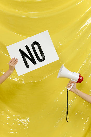 protest, hands, placard, megaphone, yellow backdrop, conceptual image, demonstration, activism, no sign, rally, shout