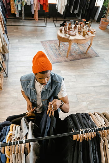 oranžová pletená čepice, Muž prochází oblečení, Butikové nakupování, režijní pohled, čepice, ramínko, Módní butik, Stylový outfit, běžné civilní oblečení, nakupování, butikový interiér