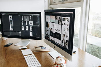 digital workspace, dual monitors, keyboard, mouse, wooden desk, silver and black iMacs, decor, office setup, computer setup, workspace design, desk accessories
