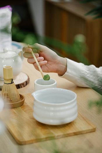 matcha čaj, bambusový šlehač, tradiční japonské nádobí, detail, Příprava ruky, matcha prášek, čajový ceremoniál, bílá mísa, dřevěný stůl, zelený čaj, příprava čaje