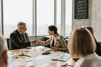 Geschäftstreffen, Kollegen, formelles Treffen, Moderner Konferenzraum, Geschäftskleidung, Hände schütteln, Gruppendiskussion, professionelle Einstellung, Büroumgebung, Teamzusammenarbeit, Geschäftsleute