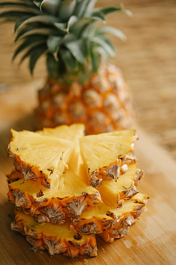 pineapple segments, sliced pineapple, wooden board, tropical freshness, pineapple slices, delicious pineapple, fresh pineapple, pineapple arrangement, tropical fruit, pineapple display, pineapple pieces