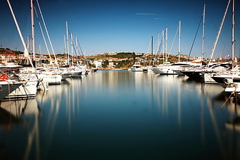 peaceful marina, sailboats, yachts, sunny day, tranquil waterfront, white cabin cruiser, calm water, marina scene, waterfront vibes, boats, reflection