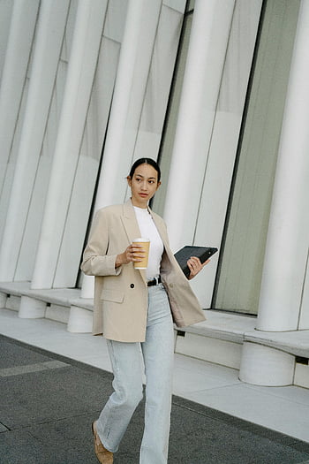 Asian businesswoman, stylish woman, laptop, takeaway coffee, urban setting, city, confident walk, young woman, modern architecture, professional look, business attire