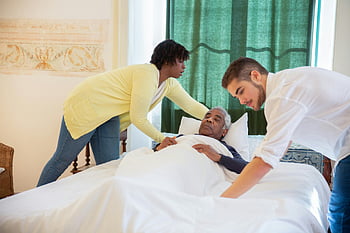 älterer Herr, im Bett liegen, Betreuer, Unterstützung bieten, Komfort, Heimpflege, Seniorenbetreuung, Nachteile am Krankenbett, ältere Pflege, Pflege, Patientenversorgung