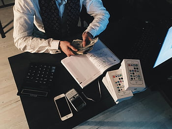 accountant counting money, businessman organizing finances, tech devices, cash on desk, financial management, office work, desk setup, business tools, money counting, financial organization, tech and cash