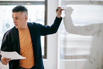 male teacher, whiteboard, explaining concepts, indoor lesson, man teaching, classroom, education, teaching methods, professional development, learning environment, presentation skills