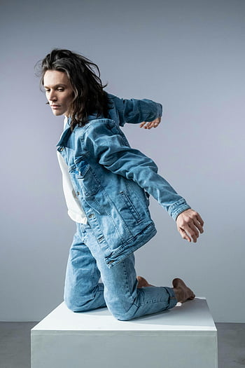 man wearing denim jacket, stylish portrait, jean jacket, jeans, dynamic pose, studio setting, fashion photography, male model, casual style, denim outfit, studio portrait