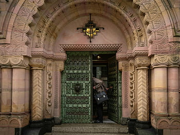 gray jacket, green door, historical doorway, ornate architecture, person entering, richly detailed, historical building, architectural details, doorway entrance, ornate door, historical entrance
