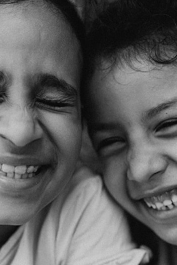 bianco e nero, bambini, volti gioiosi, sorrisi genuini, avvicinamento, commovente, due bambini, monocromatico, espressioni felici, Foto emotiva, momento sincero