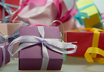 purple gift box, vivid gift boxes, ribbon adorned, close-up shot, assorted gift boxes, detailed shot, colorful ribbons, gift wrapping, festive gifts, holiday presents, decorative gifts