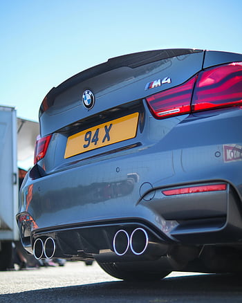 šedé auto, luxusní auto, Sportovní design, jasné modré nebe, asfaltová silnice, Venkovní parkování, bmw m4, zpětný pohled, výfukové trubky, spoiler z uhlíkových vláken, žlutá poznávací značka
