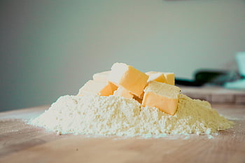 baking ingredients, butter cubes, flour pile, kitchen counter, food photography, home baking, ingredient balance, texture contrast, unprocessed, unsalted butter, yellow butter