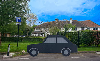 Parkplatz, Zeichen, Auto, Silhouette, Haus, Zaun, Bäume, Gras, blauer Himmel, Wolken, Kunstinstallation