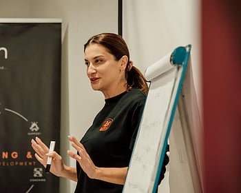 žena přednáší, seminář, přenosná prezenční papírová tabule, Vysvětlení konceptů, Moderátor, Vzdělávací událost, Profesionální vývoj, výuka, řečnictví, Nastavení třídy, dílna