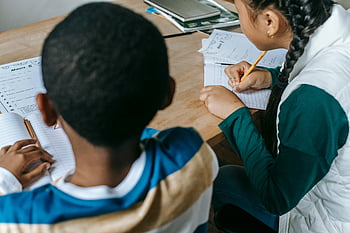 beztvářné žáky, Multietnické děti, Psaní poznámky, notebooky, rozmanité studenti, Vnitřní učebna, pozorné studium, skupinové učení, vzdělávací prostředí, zpětný pohled, Školní aktivita