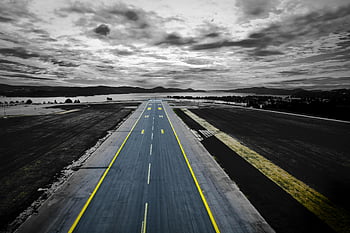 aerial photography, grey concrete road, runway, Kjevik Airport, Norway, dramatic sky, aerial shot, airport runway, concrete runway, yellow lines, dramatic clouds