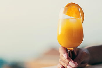 dryck, cocktail, glas, apelsinjuice, orange skiva, uppfriskande drink, citrus dryck, tropisk dryck, hand som håller glas, sommardryck