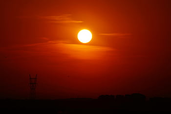 sunset, golden hour, silhouette, utility post, power line tower, landscape, evening sky, orange glow, natural scenery, outdoor photography, golden light