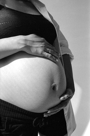 pregnant woman, black and white, cradling belly, motherhood, anticipation, emotive portrait, belly, pregnancy, black and white photography, maternity