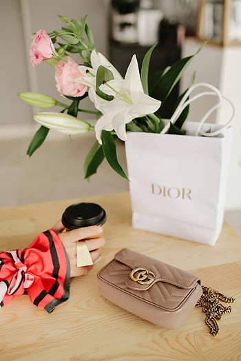 hand with ring, paper cup, handbag, flowers, shopping bag, Dior bag, coffee cup, luxurious handbag, elegant scene, Gucci bag, chain strap