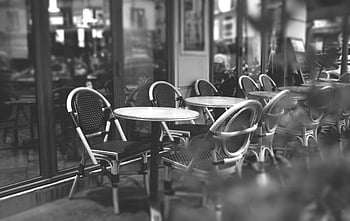 black and white, cafe terrace, Paris, empty tables, outdoor seating, serene atmosphere, urban scene, monochrome photography, street furniture, city life, round table